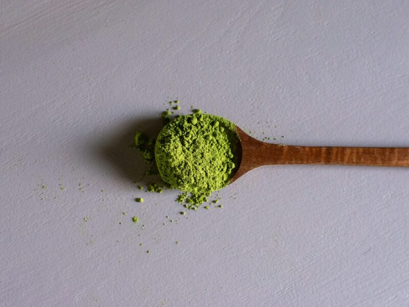 a wooden spoon filled with green powder