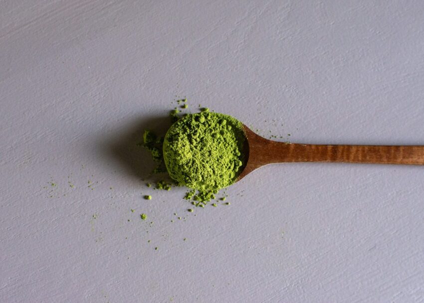 a wooden spoon filled with green powder