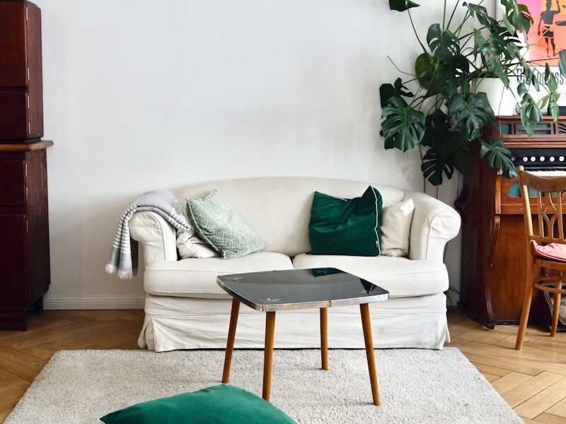 green throw pillow on white sofa