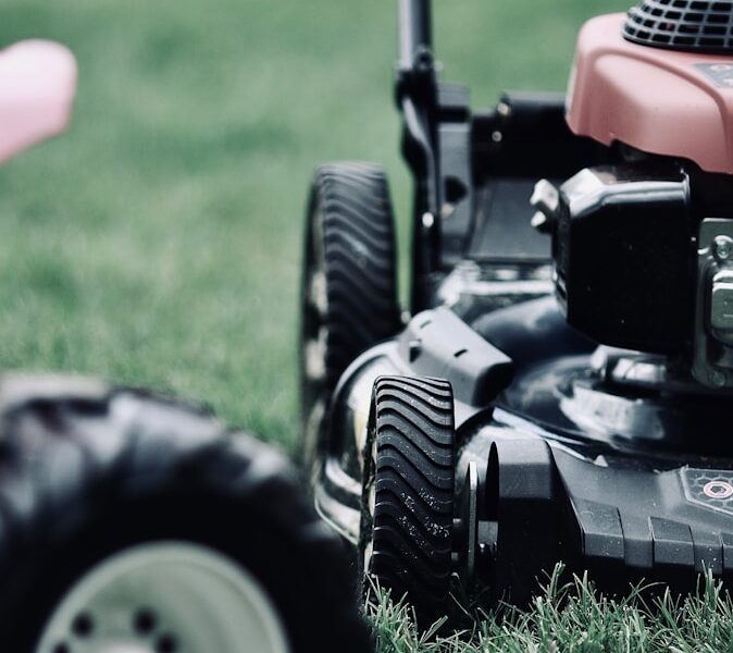 black and red ride on lawn mower on green grass field during daytime