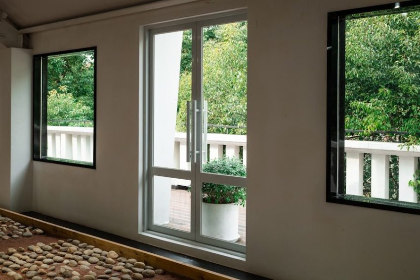 A bed sitting under three windows in a bedroom