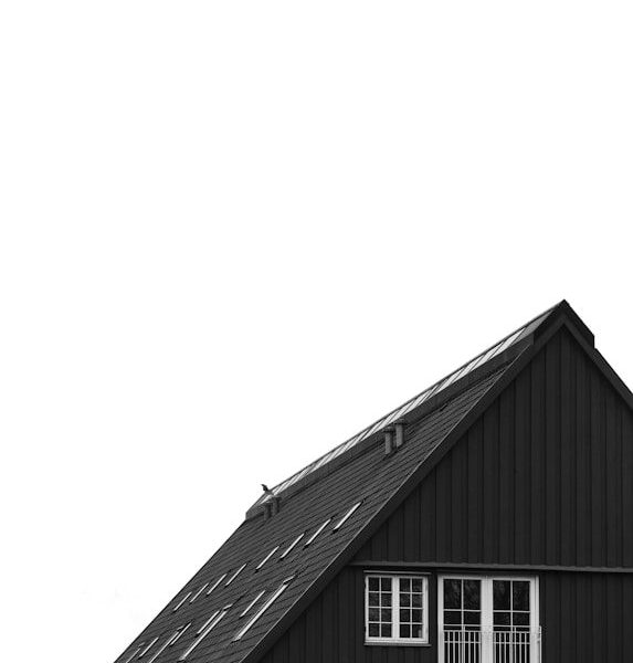 Dark wooden house with white windows against sky