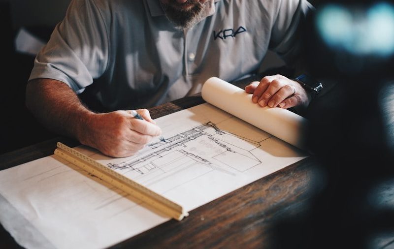 An architect working on a draft with a pencil and ruler
