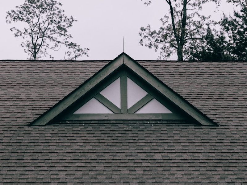 a roof with a triangle shaped window on top of it