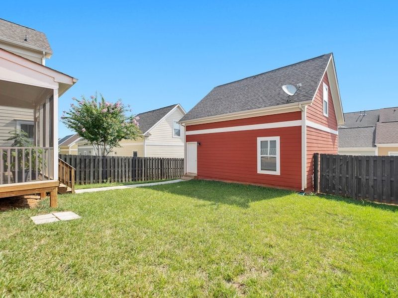 red and white wooden house on green grass field during daytime