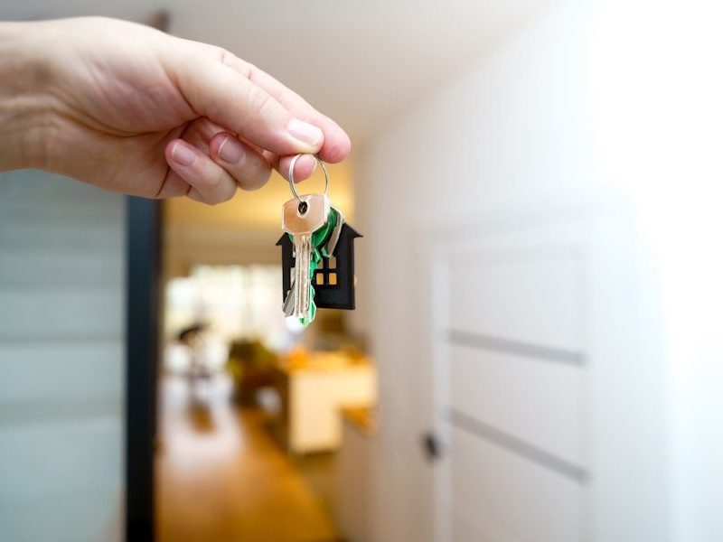 Holding house keys in front of the entrance.
