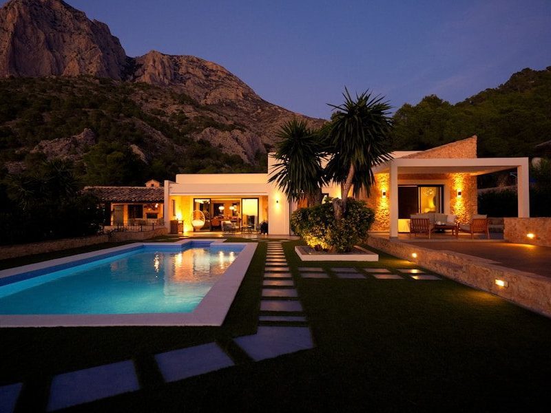 Modern house with pool at dusk near mountain