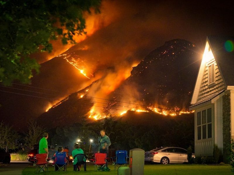 a group of people sitting in lawn chairs in front of a fire
