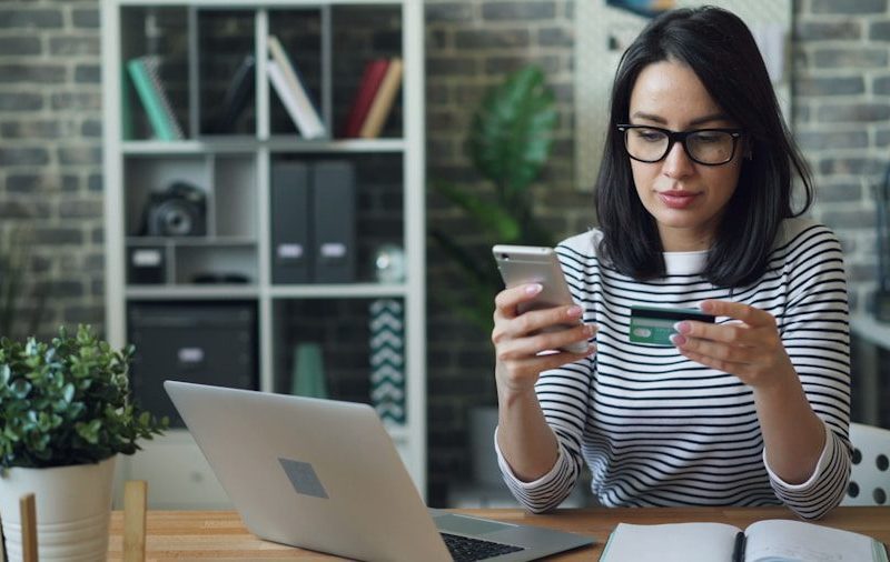 a woman sitting at a table looking at her cell phone