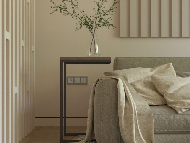 a living room with a couch and a table with a vase on it