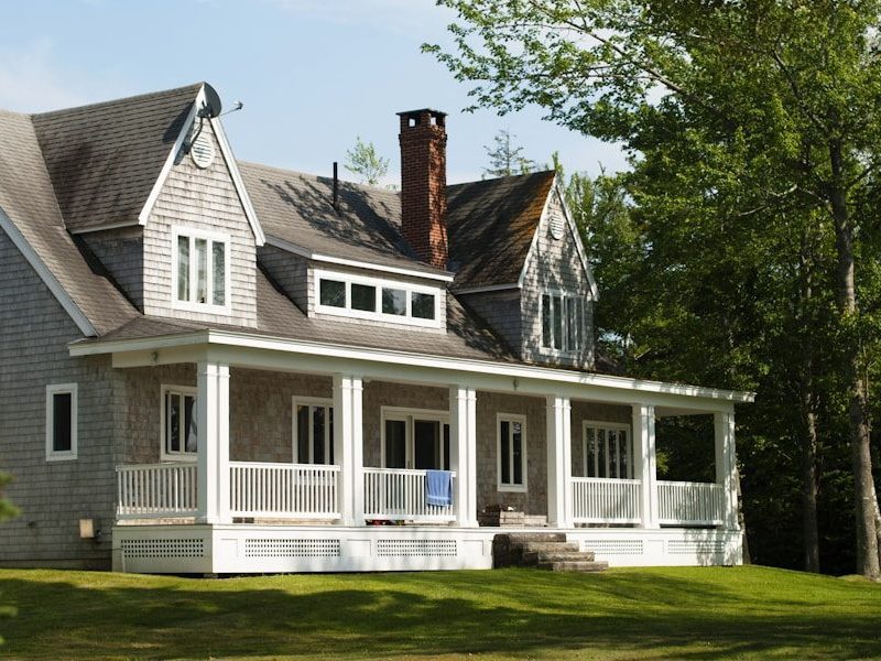 white and brown wooden house near green trees during daytime