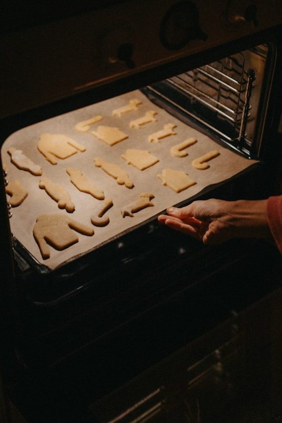 Hand placing cookie sheet into oven