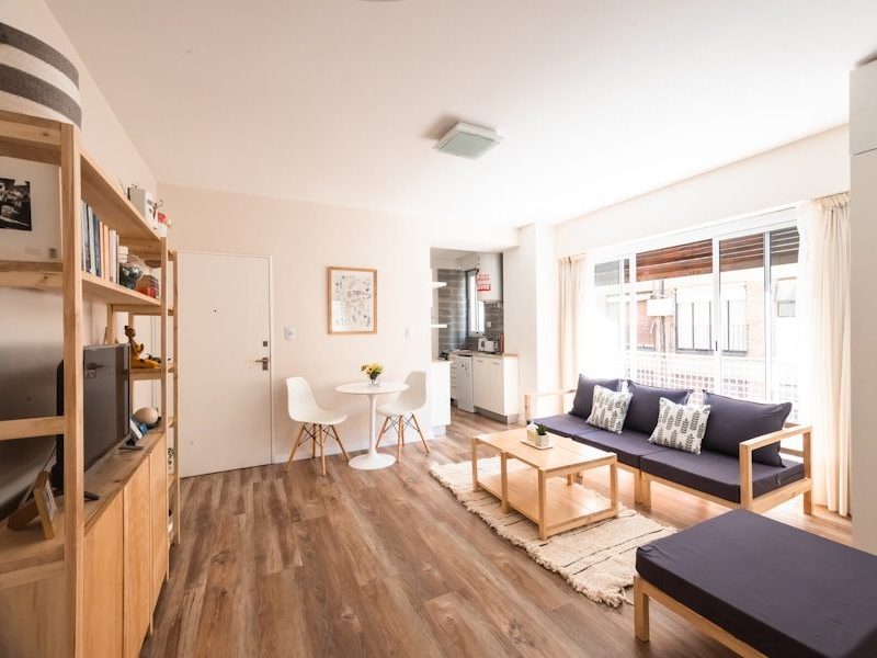 a living room with a blue couch and a wood floor