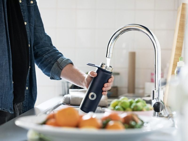 person holding stainless steel faucet