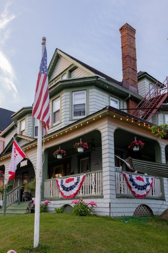 an american flag on a pole in front of a house