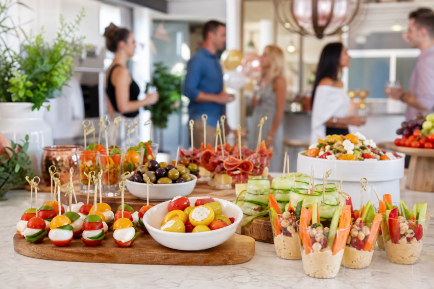 Elegant spread of appetizers and guests mingling at a party.
