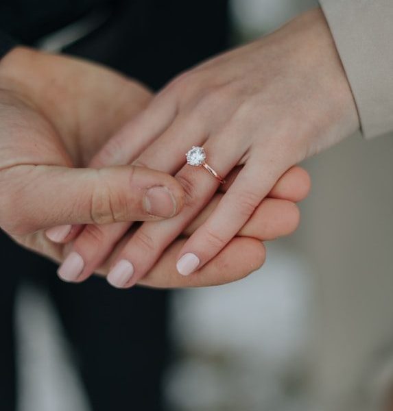 a close up of two people holding hands