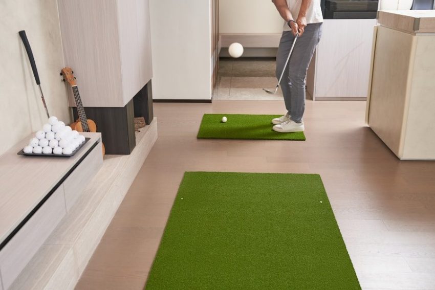 Person practicing golf indoors with putting mats.