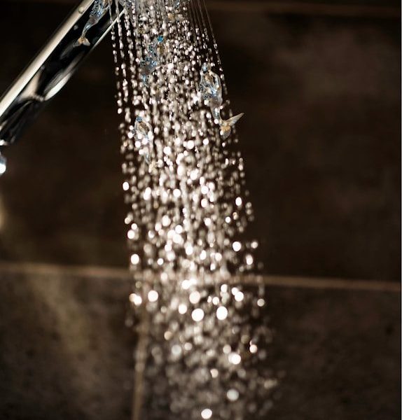 a close up of a shower head with water coming out of it