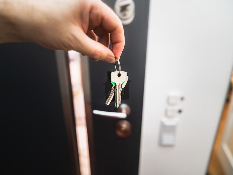 A person is holding a key to a door