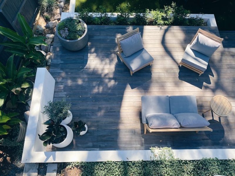 An aerial view of a wooden deck with outdoor furniture and potted plants