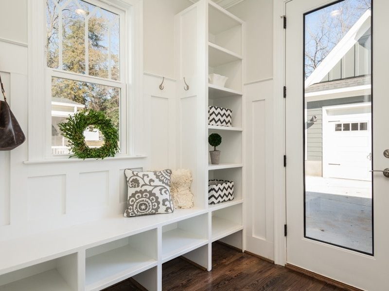 gray and white floral throw pillow beside rack inside room