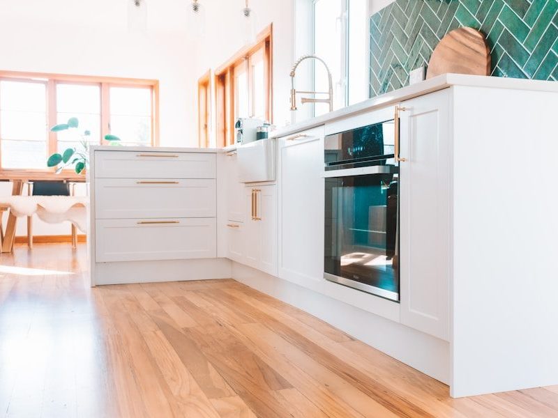 a kitchen with white cabinets and a wood floor