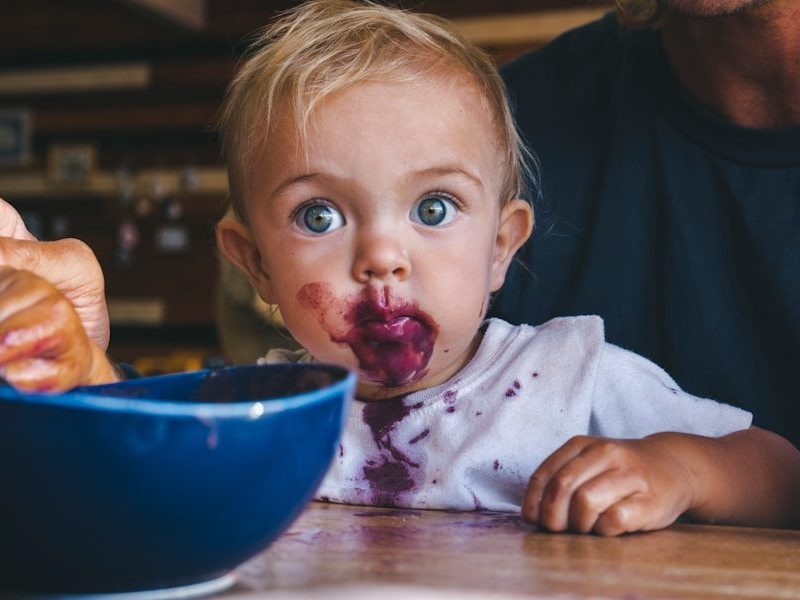 a little girl with food all over her face
