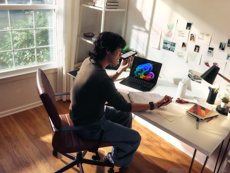 Person working at a desk with a laptop and books