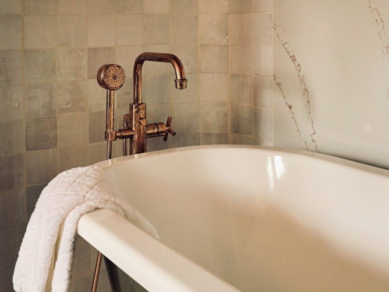 white ceramic bathtub with stainless steel shower head