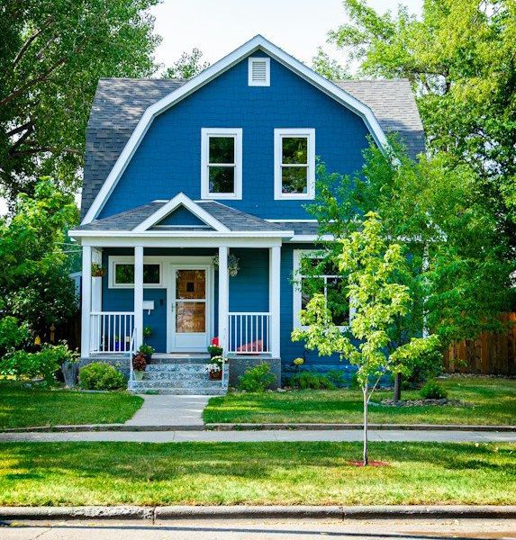 blue and white wooden house near green trees during daytime