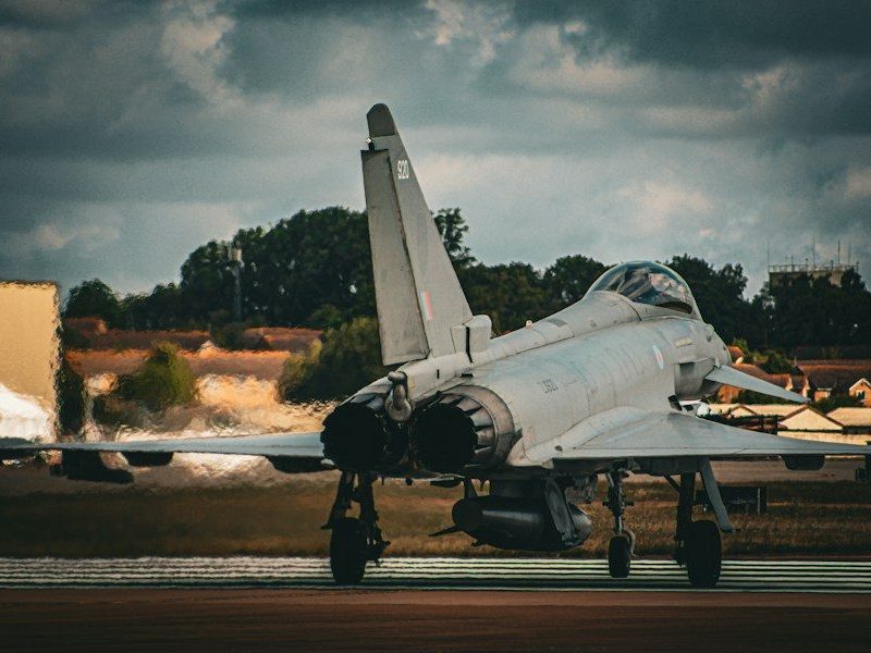 a fighter jet sitting on top of an airport runway